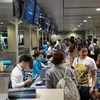 Hành khách làm thủ tục hàng không để lên chuyến bay. (Ảnh: CTV/Vietnam+)