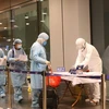 Công dân Việt Nam được hướng dẫn khử trùng trước khi làm thủ tục nhập cảnh tại sân bay Vân Đồn (Quảng Ninh).(Ảnh: Dương Giang/TTXVN)