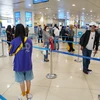 Hành khách tuân thủ khoảng cách tối thiểu 2m khi làm thủ tục tại sân bay Nội Bài sau hai ngày nới lỏng giãn cách xã hội. (Ảnh: Phan Công/Vietnam+)