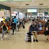 Hành khách tuân thủ giữ khoảng cách khi ngồi tại nhà ga tại sân bay Nội Bài. (Ảnh: Phan Công/Vietnam+)