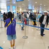 Hành khách tuân thủ khoảng cách tối thiểu 2m khi làm thủ tục tại sân bay Nội Bài sau hai ngày nới lỏng giãn cách xã hội. (Ảnh: Phan Công/Vietnam+)