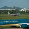 Máy bay của hai hãng hàng không Vietnam Airlines và Jetstar Pacific hạ cánh tại một sân bay. (Ảnh: Hoàng Anh/Vietnam+)