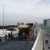 Nhà thầu đang tiến hành thi công thảm nhựa đường trên cầu cạn Mai Dịch-Nam Thăng Long. (Ảnh: Việt Hùng/Vietnam+)