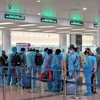 Hành khách trên chuyến bay quốc tế thương mại tới Việt Nam đầu tiên sau thời gian dài vì dịch COVID-19 làm thủ tục nhập cảnh tại sân bay Nội Bài. (Ảnh: CTV/Vietnam+)