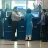 Hành khách làm dịch vụ thủ tục trực tuyến vé máy bay tại quầy Kios Vietnam Airlines ở một số sân bay. (Ảnh: Việt Hùng/Vietnam+)