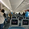 Hành khách trên một chuyến bay thực hiện nghiêm việc đeo khẩu trang theo đúng quy định. (Ảnh: CTV/Vietnam+)