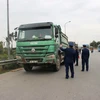 Lực lượng Thanh tra giao thông vận tải xử lý xe chở hàng quá tải trọng lưu thông qua cầu Thăng Long. (Ảnh: CTV/Vietnam+)
