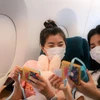 Các hành khách nữ thích thú trước món quà bất ngờ từ Vietnam Airlines nhân ngày 8/3. (Ảnh: CTV/Vietnam+)