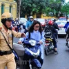 Cảnh sát giao thông sẽ xử lý những học sinh điều khiển xe máy không đội mũ bảo hiểm. (Ảnh: CTV/Vietnam+)