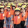 Học sinh trường tiểu học Sơn Lôi A tham gia hướng dẫn đội mũ bảo hiểm đúng cách. (Ảnh: CTV/Vietnam+)