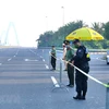 Lực lượng chức năng lập rào chắn triển khai chốt từ đường Võ Chí Công lên cầu Nhật Tân. (Ảnh: Hoàng Hiếu/TTXVN)