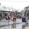 Hành khách xách đồ đạc sau chuyến trở về thành phố mệt nhoài vì ken cứng phương tiện. (Ảnh: Việt Hùng/Vietnam+)