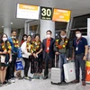 Lãnh đạo và phi hành đoàn Vietjet chào đón những hành khách trên chuyến bay đầu tiên từ Hà Nội đến Mumbai. (Ảnh: CTV/Vietnam+)
