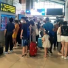 Hành khách theo dõi lịch bay của hãng hàng không tại sân bay Nội Bài. (Ảnh: Việt Hùng/Vietnam+)