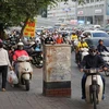 Tình trạng người điều khiển xe máy đội mũ bảo hiểm không đạt chuẩn vẫn còn phổ biến tại Việt Nam. (Ảnh: Việt Hùng/Vietnam+)
