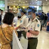 Nhân viên an ninh hàng không kiểm tra giấy tờ hành khách đi máy bay. (Ảnh: CTV/Vietnam+)