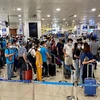 Hành khách xếp hàng để làm thủ tục an ninh soi chiếu tại sân bay Nội Bài. (Ảnh: CTV/Vietnam+)