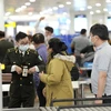 Hành khách làm thủ tục an ninh tại sân bay Nội Bài. (Ảnh: CTV/Vietnam+)