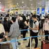 Hành khách xếp hàng dài vào làm thủ tục soi chiếu an ninh tại Cảng hàng không quốc tế Nội Bài. (Ảnh: CTV/Vietnam+)