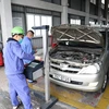 Nhân viên đăng kiểm thực hiện quy trình kiểm định xe cơ giới tại một trung tâm đăng kiểm ở Hà Nội. (Ảnh: Minh Hiếu/Vietnam+)