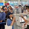 Nhân viên an ninh hàng không kiểm tra thủ tục bay của hành khách. (Ảnh: CTV/Vietnam+)