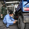 Nhân viên đăng kiểm thực hiện quy trình kiểm định xe cơ giới tại trung tâm đăng kiểm ở Hà Nội. (Ảnh: Hoài Nam/Vietnam+)