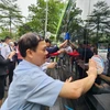 Các đại biểu dán các khẩu hiệu tuyên truyền trên xe buýt điện nhằm ủng hộ Tuần lễ An toàn giao thông đường bộ toàn cầu lần thứ 7. (Ảnh: Việt Hùng/Vietnam+)