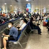 Hành khách ngồi chờ lên máy bay tại Cảng hàng không quốc tế Tân Sơn Nhất. (Ảnh: Việt Hùng/Vietnam+)