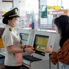 Nhân viên an ninh hàng không kiểm tra giấy tờ tùy thân của hành khách trước khi vào khu vực soi chiếu để làm thủ tục lên máy bay. (Ảnh: PV/Vietnam+)