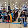 Hành khách làm thủ tục soi chiếu trước khi lên máy bay tại Cảng hàng không quốc tế Nội Bài. (Ảnh: CTV/Vietnam+)