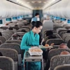 Tiếp viên của Hãng hàng không Vietnam Airlines phục vụ suất ăn trên chuyến bay. (Ảnh: CTV/Vietnam+)