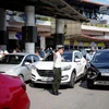 Nhân viên an ninh hàng không Cảng hàng không Quốc tế Nội Bài hướng dẫn, phân luồng xe đi vào sân bay. (Ảnh: PV/Vietnam+)
