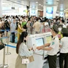 Hành khách làm thủ tục kiểm tra an ninh tại một sân bay. (Ảnh: PV/Vietnam+)