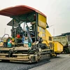 Nhà thầu thi công thảm nhựa nền đường một tuyến Quốc lộ. (Ảnh: Việt Hùng/Vietnam+)