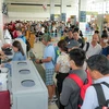 Nhân viên an ninh hàng không kiểm tra giấy tờ hành khách đi máy bay. (Ảnh: PV/Vietnam+)