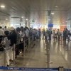 Hành khách xếp hàng vào khu làm thủ tục soi chiếu an ninh tại Sân bay Tân Sơn Nhất. (Ảnh: Việt Hùng/Vietnam+)