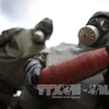 Các nhân viên trong trang phục bảo hộ diễn tập tại khu vực tiêu hủy vũ khí hóa học ở Munster,miền bắc nước Đức ngày 30/10/2013. (Nguồn: AFP/TTXVN)