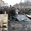Người biểu tình dỡ những chướng ngại vật trong cuộc biểu tình ở Kiev ngày 21/1. (Nguồn: AFP/TTXVN)