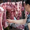 Khách hàng chọn mua thịt lợn tại khu chợ ở Yichang, tỉnh Hồ Bắc, Trung Quốc. (Nguồn: AFP/TTXVN)