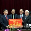 Ông Lê Thanh Hải trao tượng trưng số tiền 30 tỷ đồng của TP Hồ Chí Minh tặng nhân dân Điện Biên xây dựng Bệnh viện Đa khoa huyện Mường Ảng.( Ảnh: Chu Quốc Hùng/TTXVN)