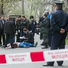 Cảnh sát điều tra tại hiện trường vụ sát hại nhà báo Oles Buzyna ở Kiev, Ukraine ngày 16/4. (Nguồn: AFP/TTXVN)