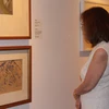 Người xem chăm chú trước các tác phẩm trưng bày tại triển lãm. (Ảnh: Lê Hải/Vietnam+)
