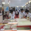 Người dân nghiên cứu các tài liệu, bản đồ - là chứng cứ lịch sử và cơ sở pháp lý về chủ quyền của Việt Nam đối với Hoàng Sa và Trường Sa tại Nam Định. (Ảnh: Văn Đạt/TTXVN)