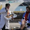 Thủ tướng Nhật Bản Shinzo Abe ăn một con cá nướng tại cảng cá Soma Haragama ở tỉnh Fukushima. (Nguồn: Reuters)