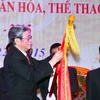 Trưởng ban Tư tưởng Văn hóa Trung ương Đinh Thế Huynh gắn Huân chương Hồ Chí Minh lên lá cờ truyền thống của ngành văn hóa. (Ảnh: Quý Trung/TTXVN)