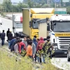 Người di cư tiếp cận các xe tải tới cảng Calais của Pháp ngày 5/8. (Nguồn: AFP/TTXVN)