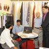 Các doanh nghiệp Việt Nam và doanh nghiệp Ấn Độ trao đổi về sản phẩm dệt may. (Ảnh: Kim Phương/TTXVN)