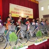  Ông Trương Hòa Bình trao tặng xe đạp cho các học sinh dân tộc nghèo vượt khó tại Trường Tiểu học thị trấn Cao Lộc. (Ảnh: Hoàng Nam/TTXVN)