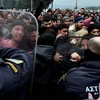 Cảnh sát Macedonia ngăn dòng người di cư đang tìm cách phá hàng rào biên giới ở Idomeni. (Nguồn: AFP/TTXVN)