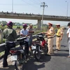 Lực lượng chức năng kiểm tra những người đi xe máy trái luật trên đường cao tốc Long An. (Ảnh: Bùi Như Trường Giang/TTXVN)